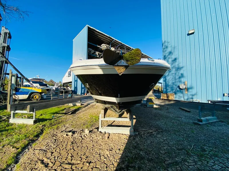 Slide: The Image of 2022 Sea Ray 270 SDX boat on stands, near blue storage building, sunny day. - 8