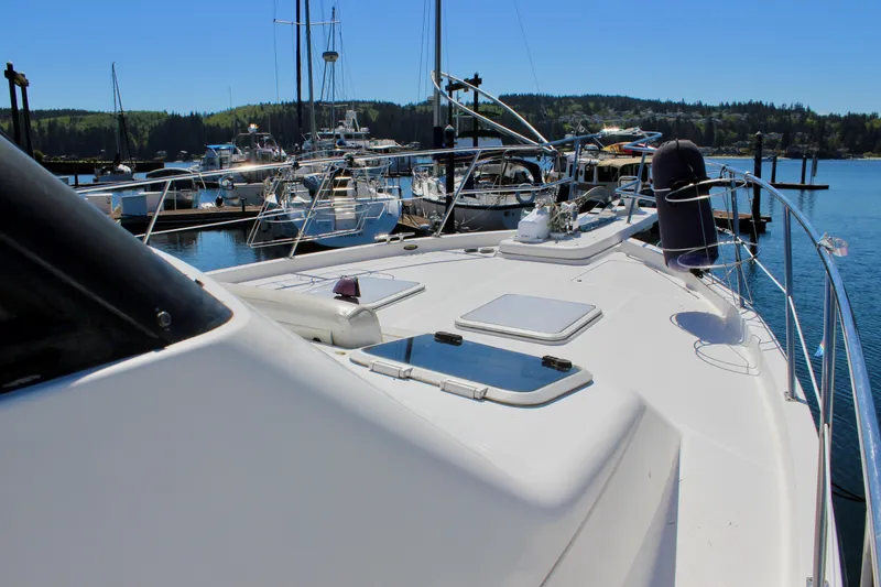 Slide: The Image of 1999 Bayliner 4788 Motoryacht docked in a scenic marina setting. - 14