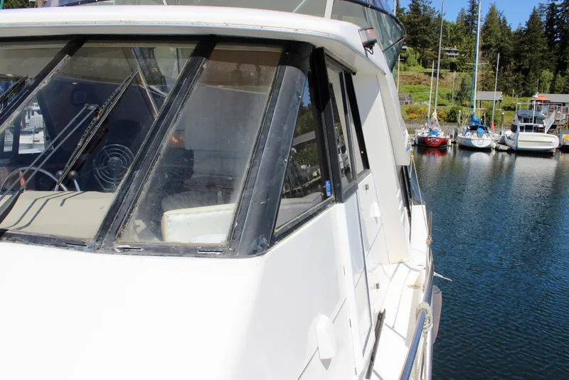 Slide: The Image of 1999 Bayliner 4788 Motoryacht docked in a marina with surrounding boats. - 18