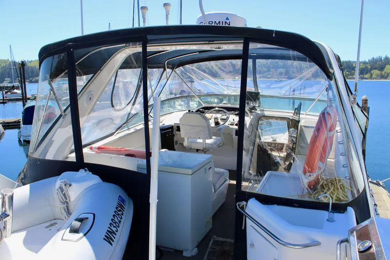 Slide: The Image of 1999 Bayliner 4788 Motoryacht docked, featuring spacious cockpit and clear canopy. - 24