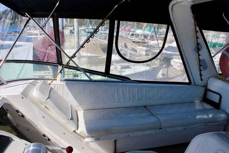 Slide: The Image of 1999 Bayliner 4788 Motoryacht interior with white seating and marina view. - 29