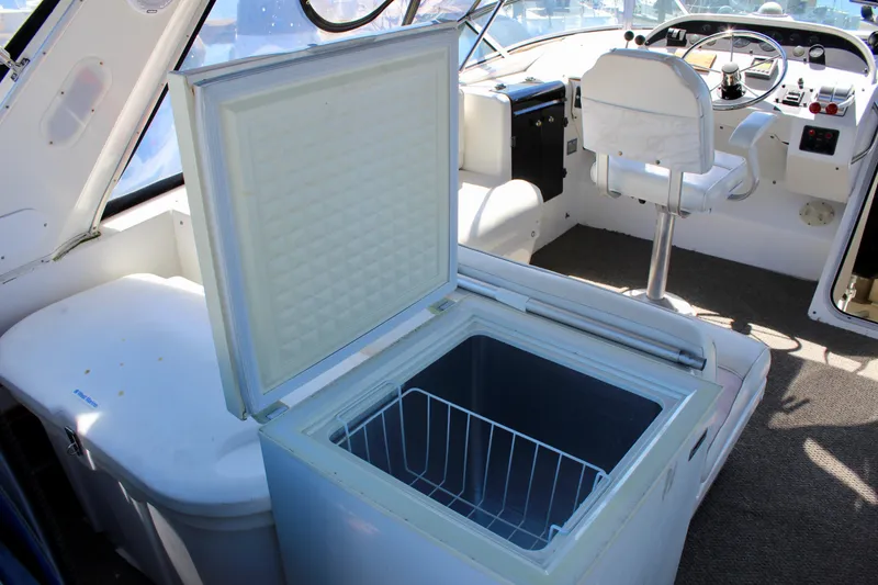Slide: The Image of 1999 Bayliner 4788 Motoryacht interior with open freezer and helm station. - 33