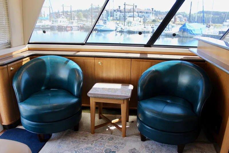 Slide: The Image of Interior of 1999 Bayliner 4788 Motoryacht with teal chairs and marina view. - 38