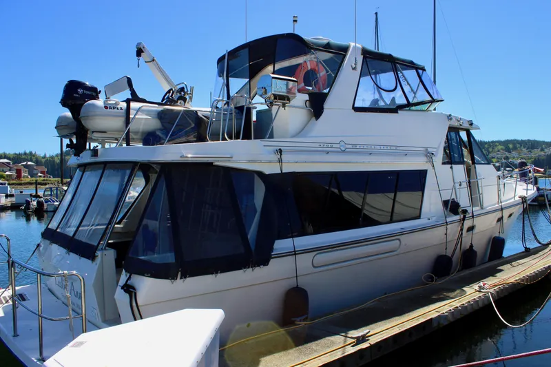 Slide: The Image of 1999 Bayliner 4788 Motoryacht docked at marina under clear blue sky. - 4