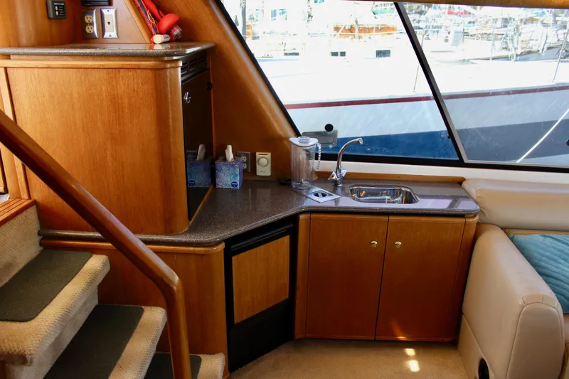 Slide: The Image of 1999 Bayliner 4788 Motoryacht interior with kitchenette, sink, and wooden cabinetry. - 45