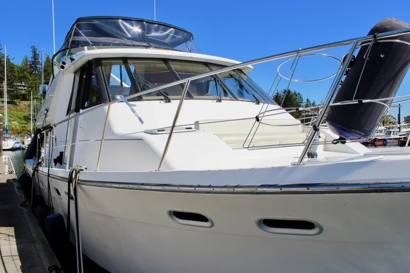 Slide: The Image of 1999 Bayliner 4788 Motoryacht docked, showcasing sleek design and spacious deck. - 6