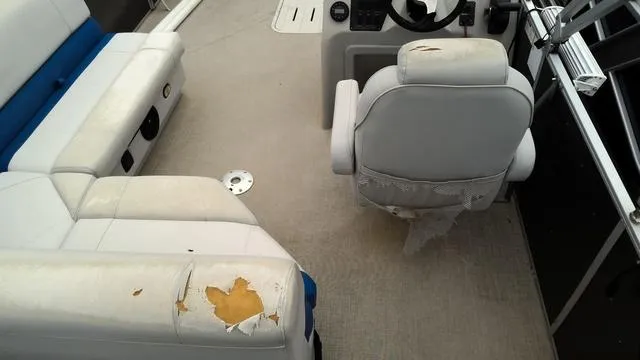 Slide: The Image of 2020 SunCatcher V322 F boat interior with worn, damaged seating and steering area. - 13