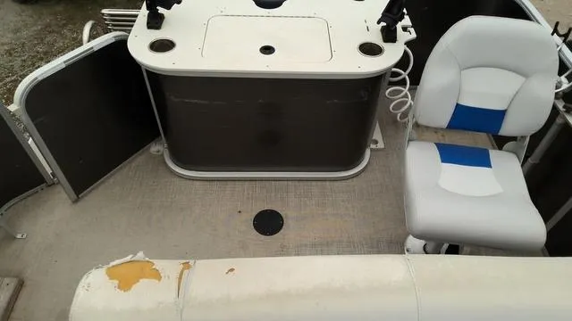 Slide: The Image of 2020 SunCatcher V322 F boat interior with seating and console, showing wear on upholstery. - 9