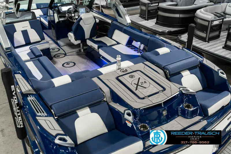 Slide: The Image of 2025 MasterCraft X24 boat interior with blue and white seating, showcased at Reeder-Trausch Marine. - 15