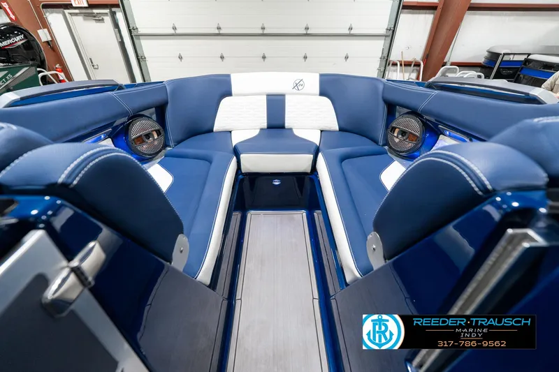 Slide: The Image of 2025 MasterCraft X24 boat interior with blue and white seating, premium sound system. - 18