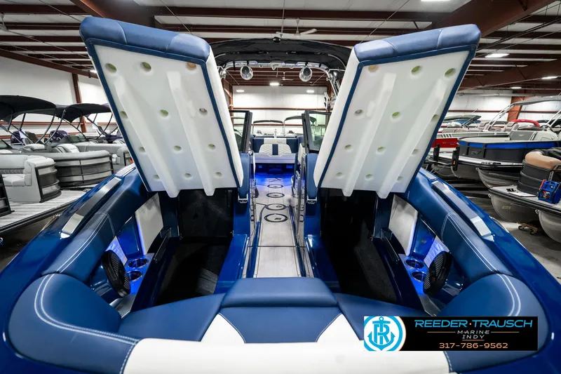 Slide: The Image of 2025 MasterCraft X24 boat interior with open storage compartments in a showroom. - 23