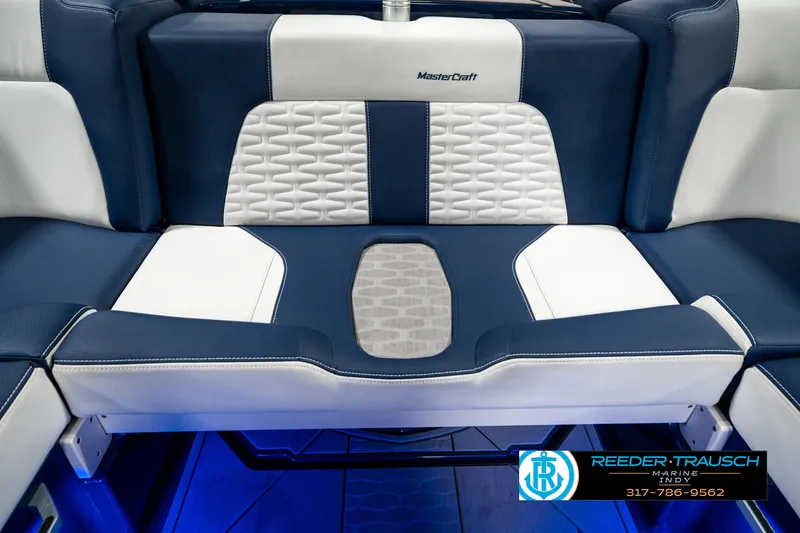 Slide: The Image of 2025 MasterCraft X24 boat interior with blue and white seating, featuring modern design and branding. - 32