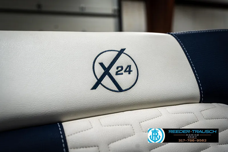 Slide: The Image of 2025 MasterCraft X24 boat seat with logo, featuring white and navy upholstery. - 49