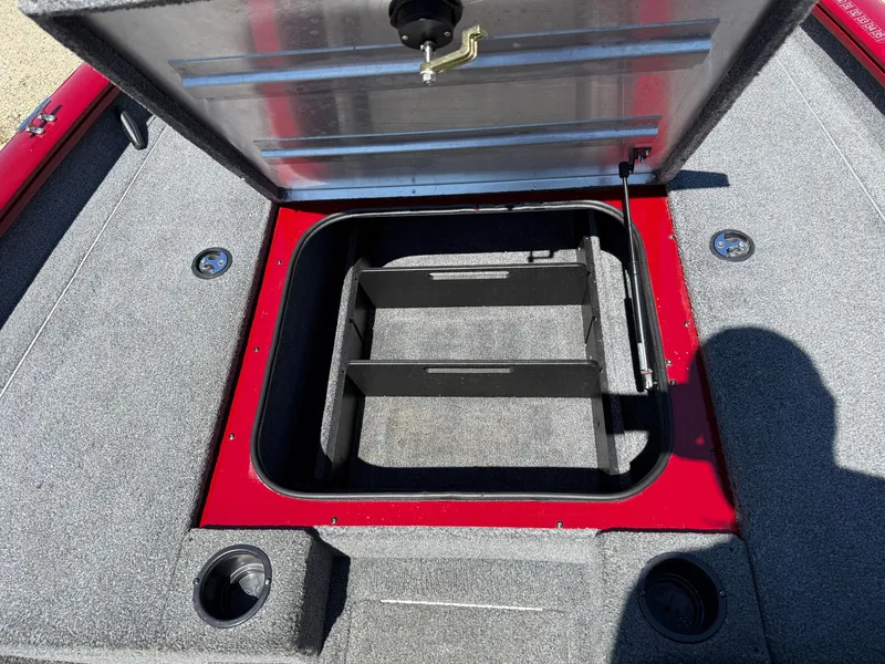 Slide: The Image of Open storage compartment on 2019 Tracker Pro Team 175 TXW boat, featuring red and gray interior. - 13