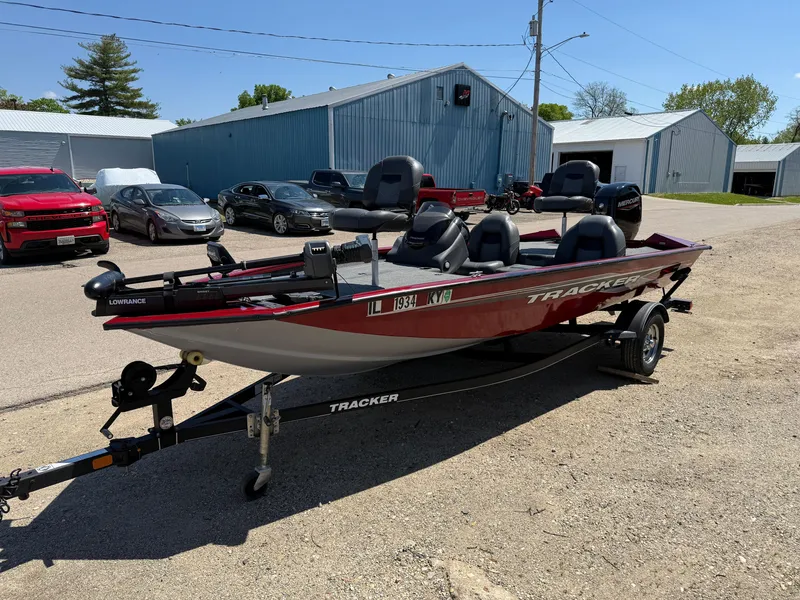 Slide: The Image of 2019 Tracker Pro Team 175 TXW boat on trailer, parked outdoors near vehicles and buildings. - 3