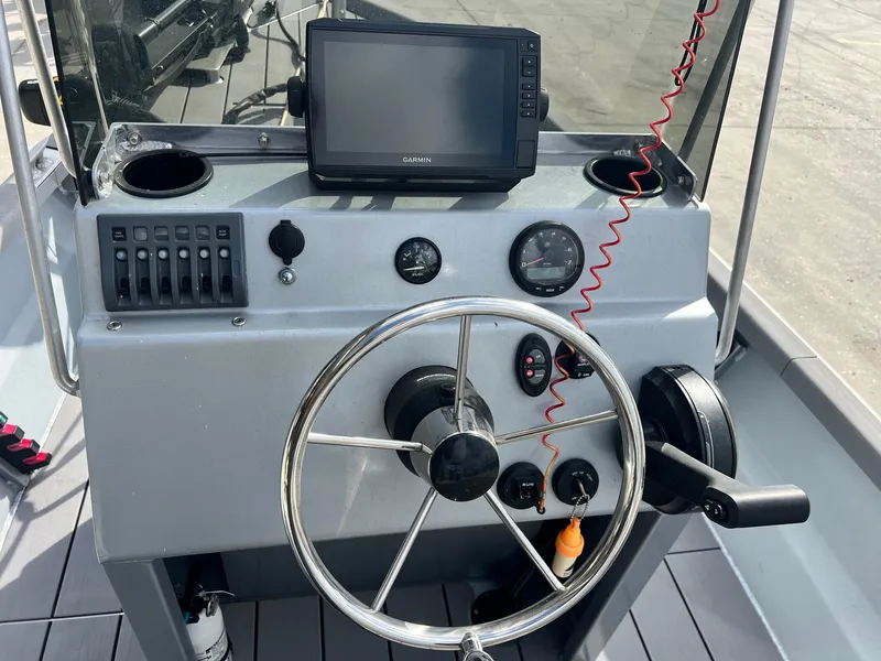 Slide: The Image of Boat dashboard with steering wheel, Garmin GPS, and controls on a 2022 Hanko 185 CCLS. - 16