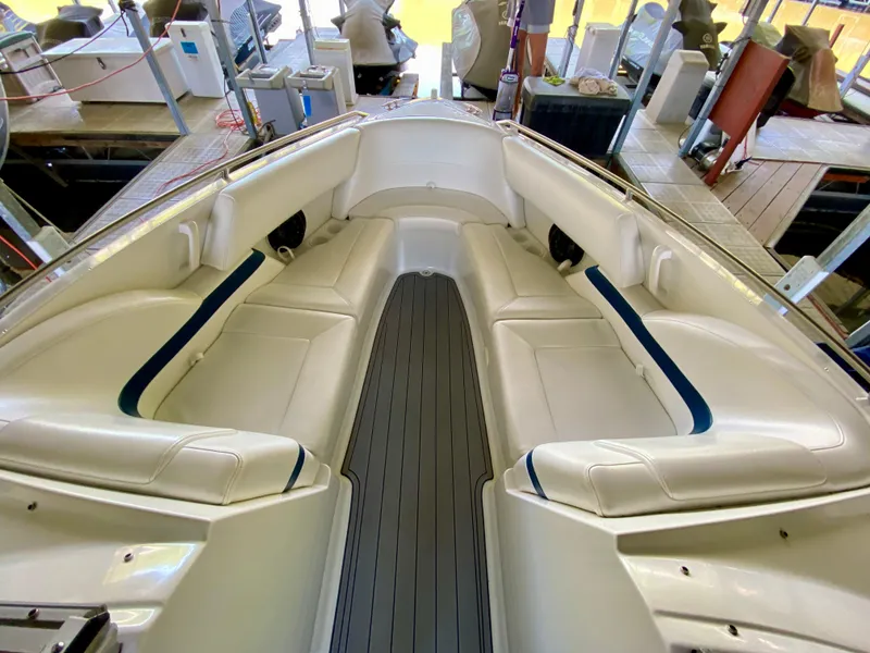 Slide: The Image of 2000 Formula 280 Bowrider interior with white seating and gray flooring in a marina setting. - 20