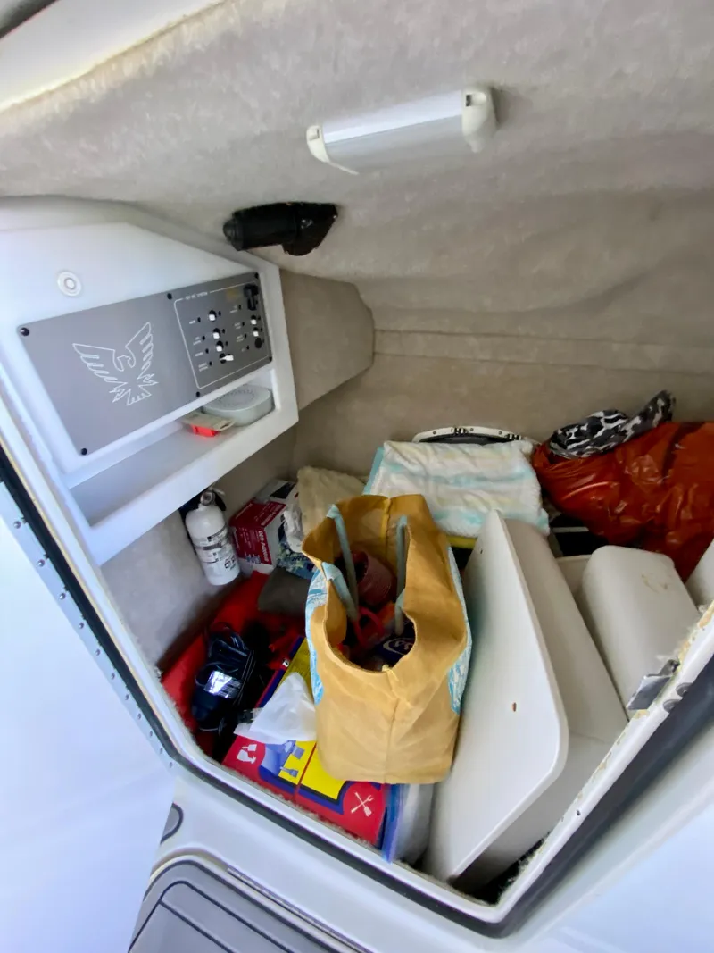 Slide: The Image of Interior storage of 2000 Formula 280 Bowrider boat with various items and control panel. - 22