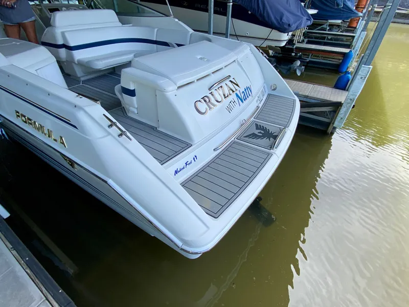 Slide: The Image of 2000 Formula 280 Bowrider boat docked, featuring spacious seating and sleek design. - 6