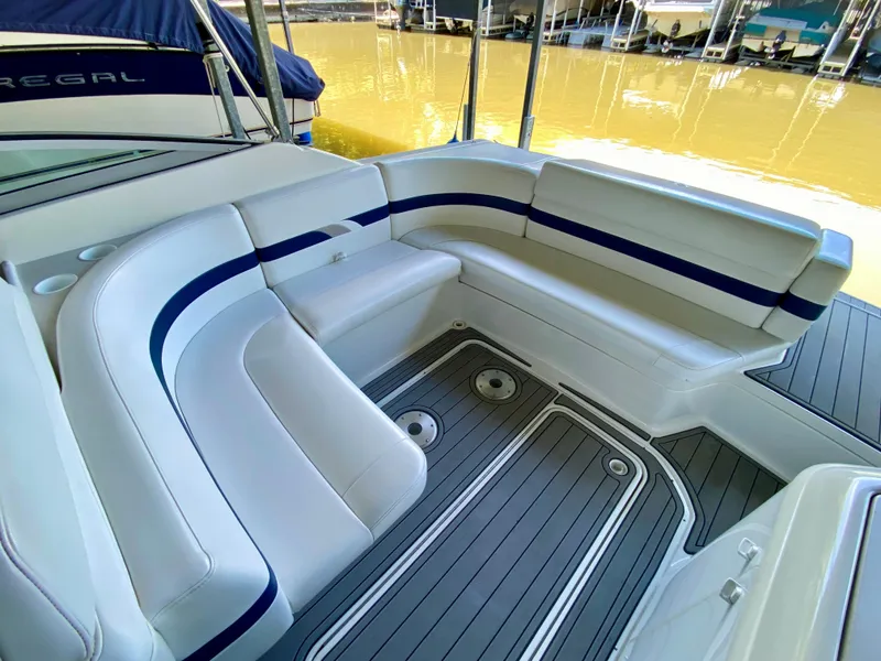 Slide: The Image of 2000 Formula 280 Bowrider boat interior with white and blue seating, docked by the water. - 9