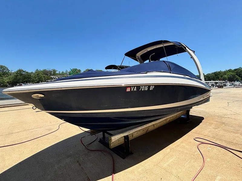 The Image of 2010 Regal 2300 RX Bowrider boat on trailer, blue hull, sunny day. - 0