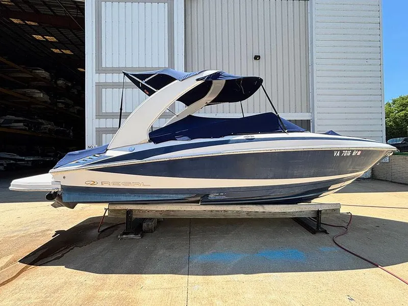 Slide: The Image of 2010 Regal 2300 RX Bowrider boat on a lift, blue and white design. - 2