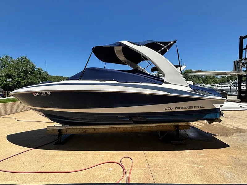 Slide: The Image of 2010 Regal 2300 RX Bowrider boat on a dock under clear blue sky. - 4