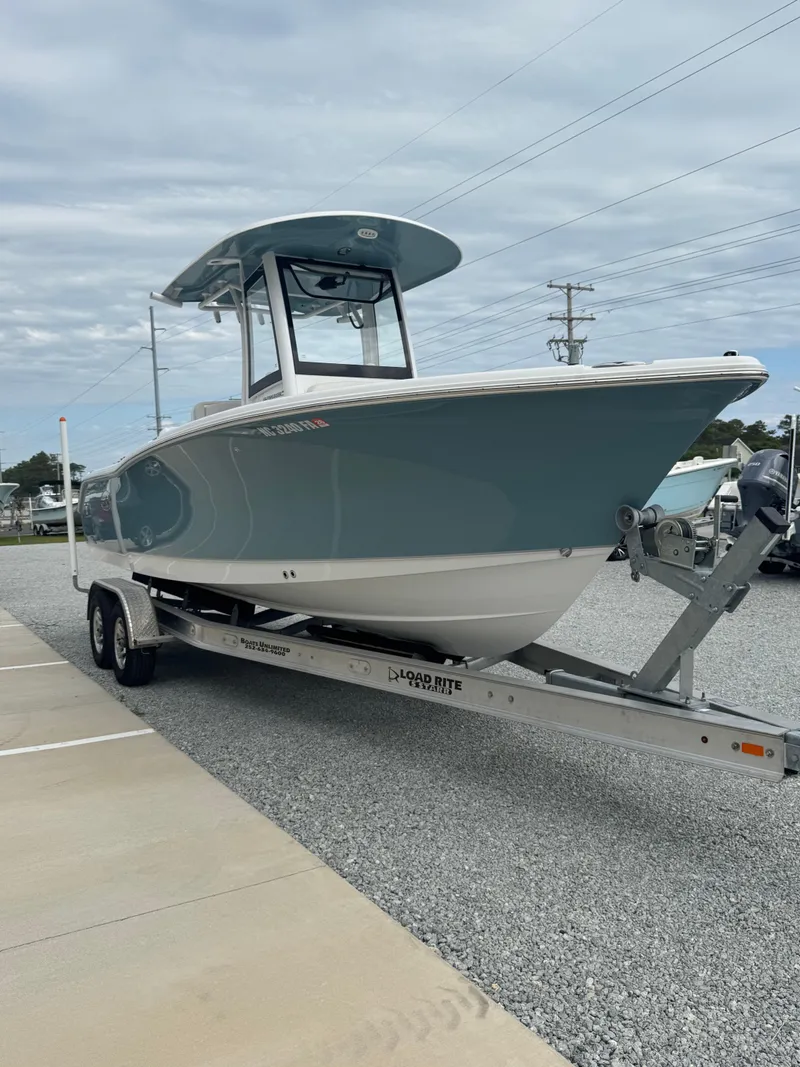 Slide: The Image of 2023 Sea Hunt Ultra 255 SE boat on trailer, parked on gravel lot. - 15