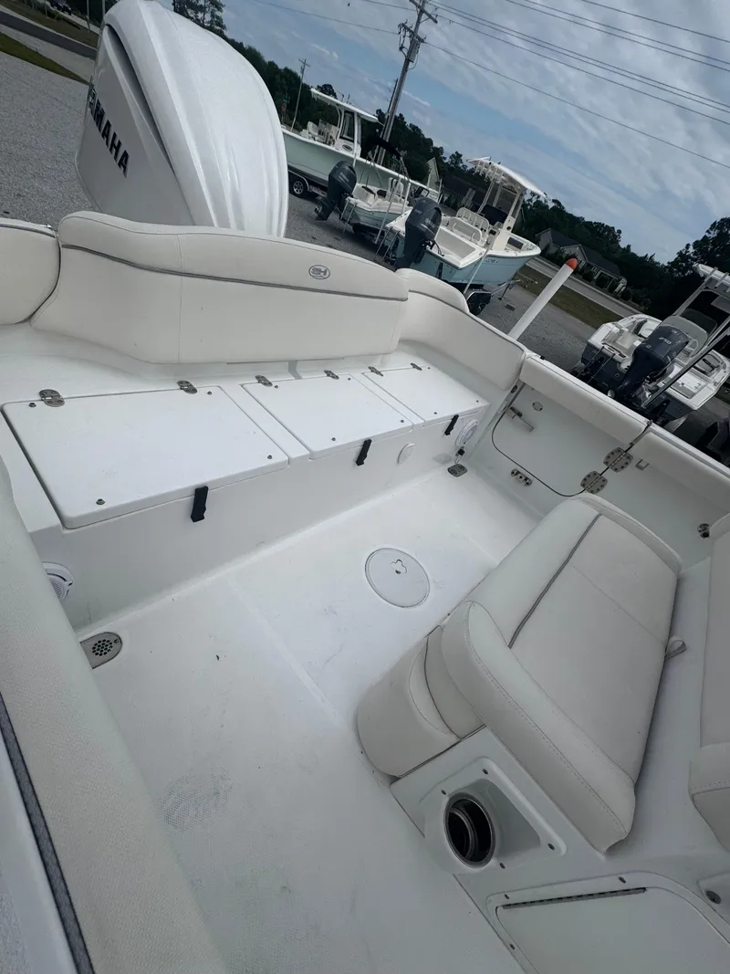 Slide: The Image of 2023 Sea Hunt Ultra 255 SE boat interior with white seating and storage compartments. - 17