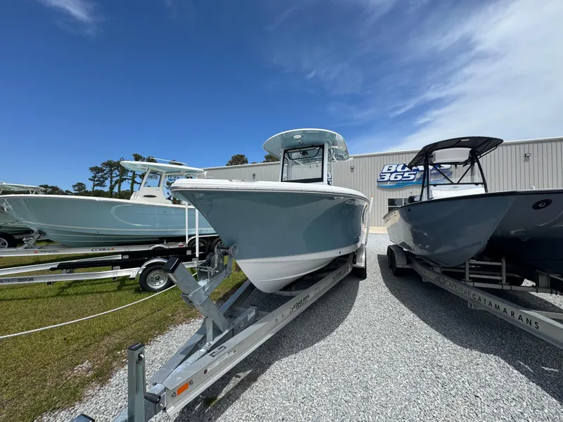 Slide: The Image of 2023 Sea Hunt Ultra 255 SE boat on trailer at dealership under blue sky. - 2