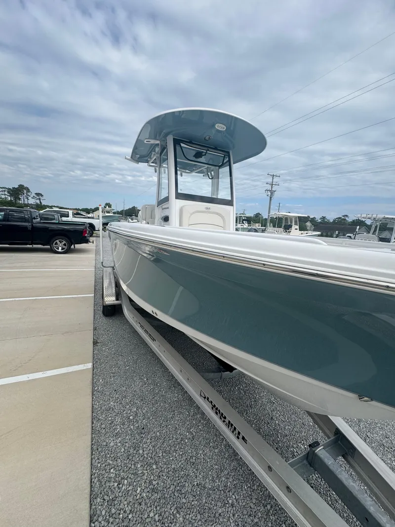 Slide: The Image of 2023 Sea Hunt Ultra 255 SE boat on trailer under cloudy sky. - 23