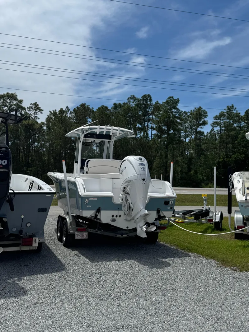 Slide: The Image of 2023 Sea Hunt Ultra 255 SE boat on trailer, parked outdoors under a clear sky. - 3