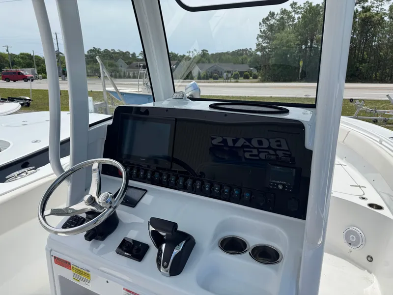 Slide: The Image of 2023 Sea Hunt Ultra 255 SE boat dashboard with steering wheel and controls. - 4