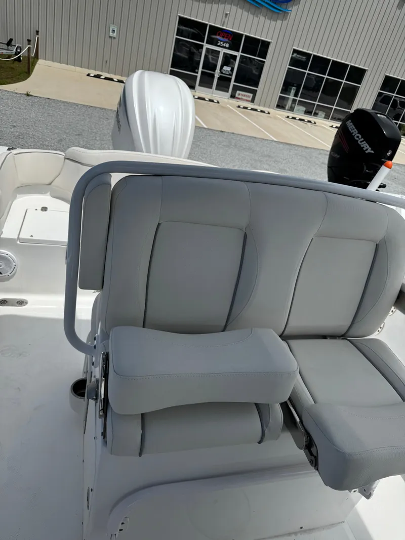 Slide: The Image of 2023 Sea Hunt Ultra 255 SE boat interior with cushioned seating and outboard motor. - 5