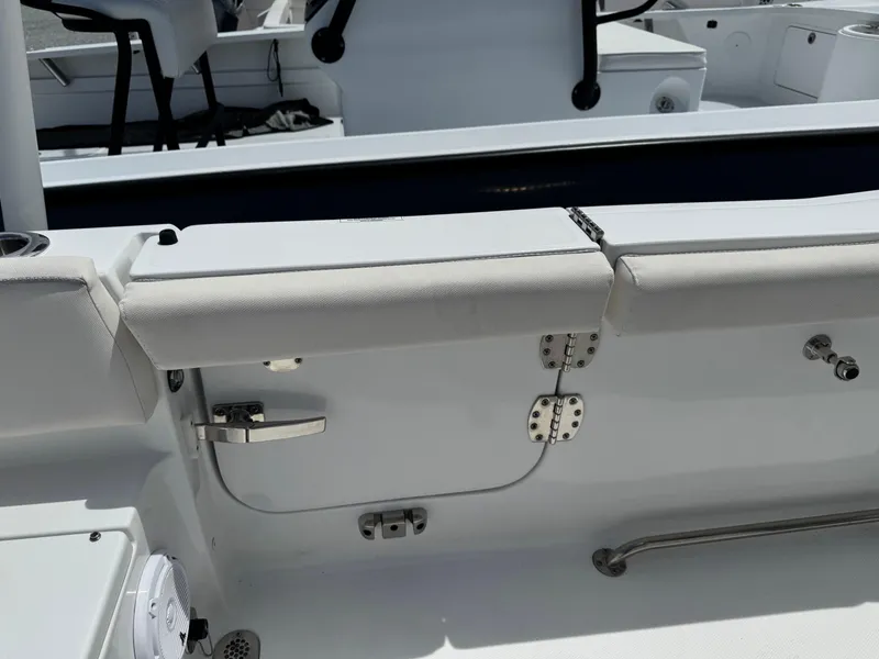 Slide: The Image of 2023 Sea Hunt Ultra 255 SE boat interior with cushioned seating and stainless steel fixtures. - 9