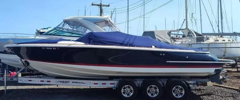 Slide: The Image of 2017 Chris-Craft Launch 28 boat on trailer, covered, docked at marina. - 1