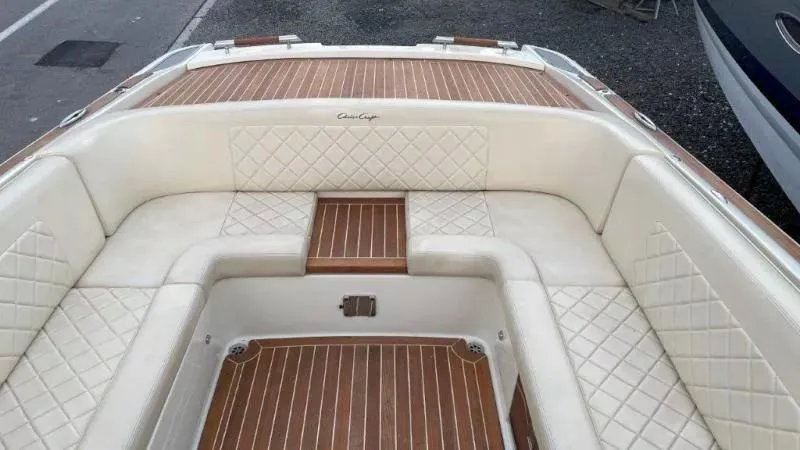 Slide: The Image of 2017 Chris-Craft Launch 28 boat interior with white quilted seating and wooden flooring. - 11