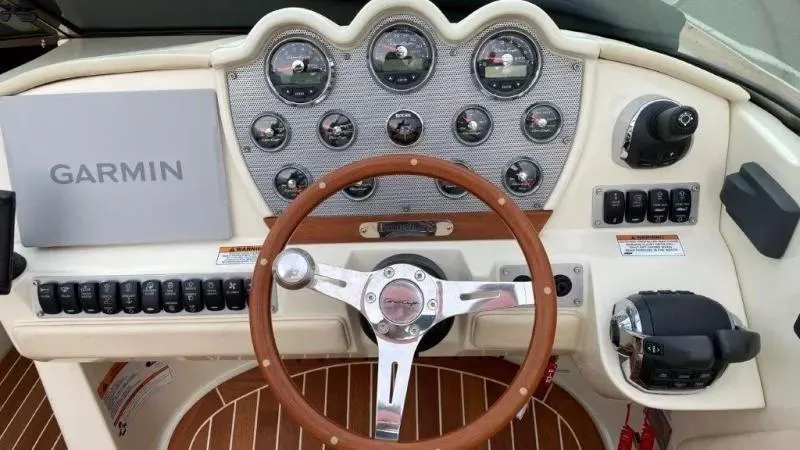 Slide: The Image of 2017 Chris-Craft Launch 28 dashboard with Garmin navigation and classic wooden steering wheel. - 14
