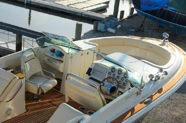 Slide: The Image of 2017 Chris-Craft Launch 28 boat interior with elegant seating and dashboard, docked by the water. - 6