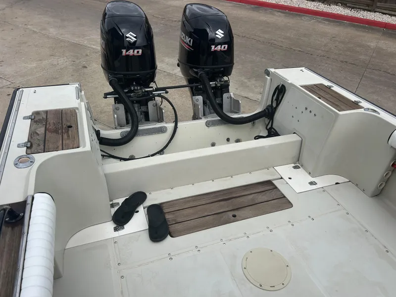 Slide: The Image of 1983 Boston Whaler 25 Outrage with twin Suzuki 140 outboard motors, docked on concrete. - 19