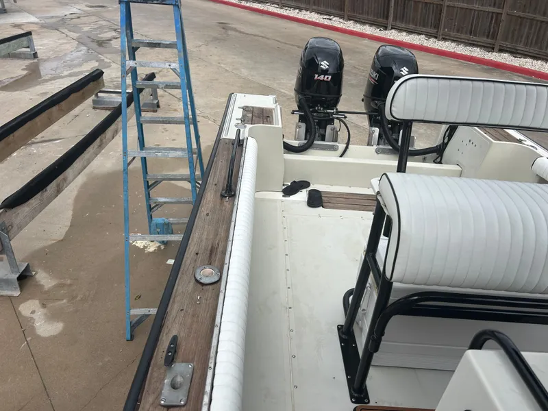 Slide: The Image of 1983 Boston Whaler 25 Outrage boat with dual Suzuki 140 engines, docked near a blue ladder. - 20