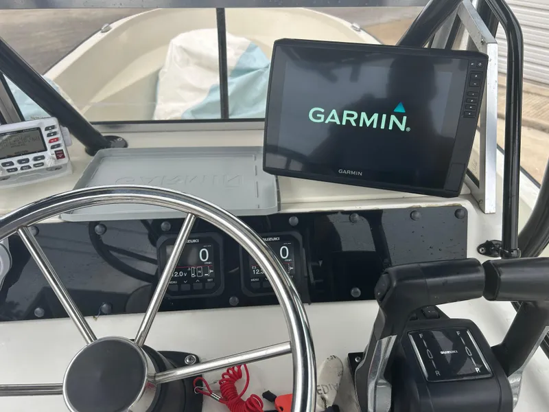 Slide: The Image of 1983 Boston Whaler 25 Outrage dashboard with Garmin navigation system and steering wheel. - 25