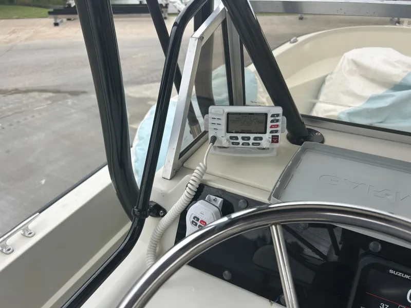 Slide: The Image of 1983 Boston Whaler 25 Outrage boat dashboard with steering wheel and marine radio. - 27