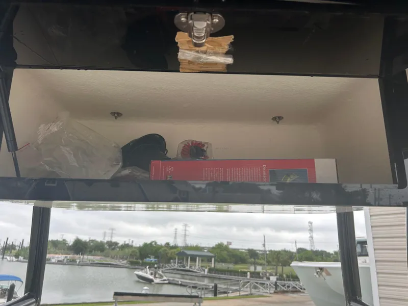 Slide: The Image of Open storage compartment on 1983 Boston Whaler 25 Outrage, with marina view in background. - 29
