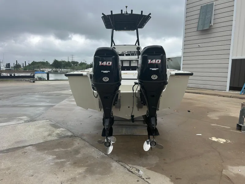 Slide: The Image of 1983 Boston Whaler 25 Outrage with twin 140 horsepower engines, docked on a cloudy day. - 3
