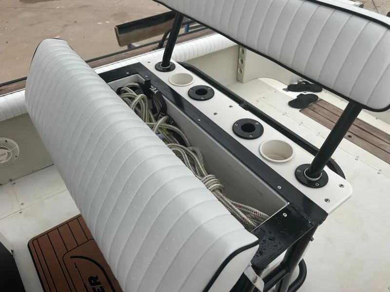 Slide: The Image of 1983 Boston Whaler 25 Outrage boat interior with white cushioned seating and storage compartment. - 34