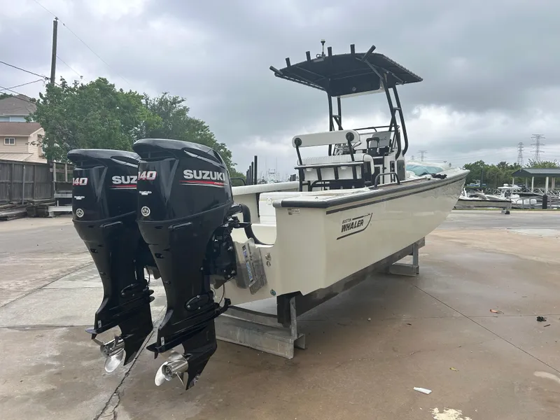 Slide: The Image of 1983 Boston Whaler 25 Outrage boat with dual Suzuki outboard motors on a concrete dock. - 4