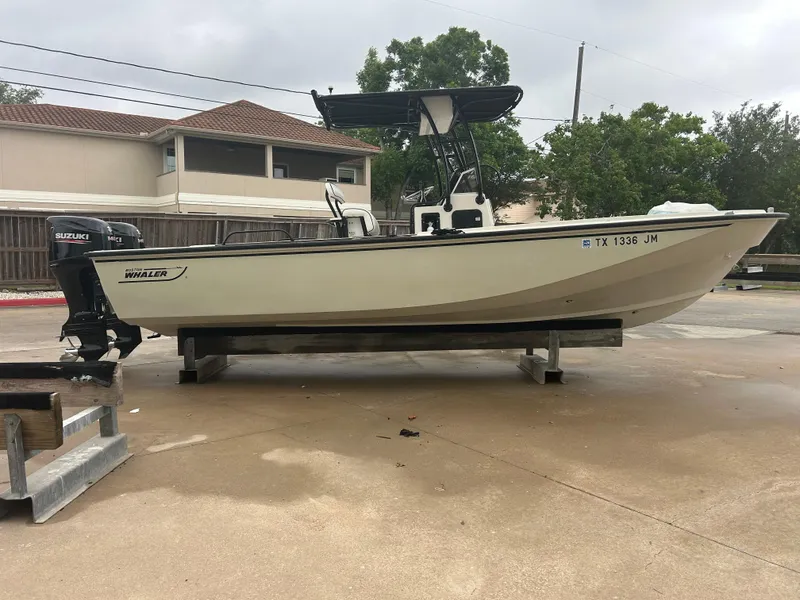 Slide: The Image of 1983 Boston Whaler 25 Outrage boat on trailer, parked outdoors. - 5