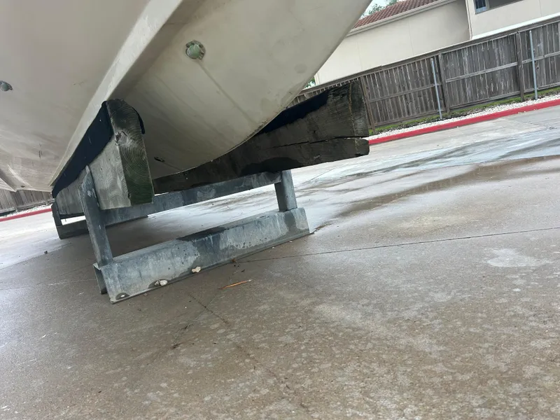 Slide: The Image of 1983 Boston Whaler 25 Outrage boat hull on trailer, parked on wet pavement. - 7