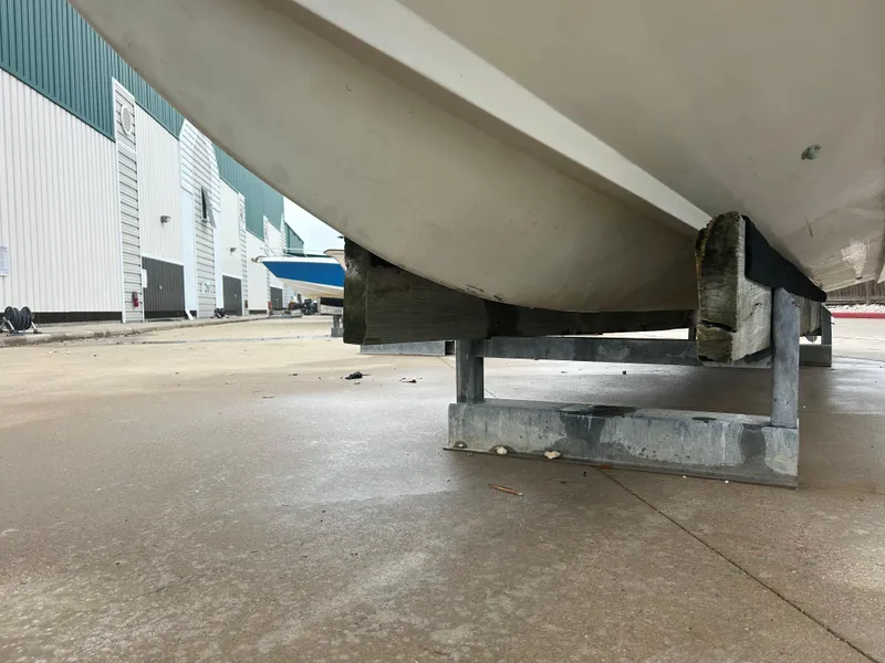 Slide: The Image of 1983 Boston Whaler 25 Outrage boat on trailer, viewed from below, in a marina setting. - 8